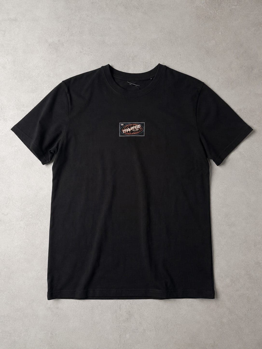 Black graphic t-shirt, raw phone photo on a bed next to a studio-lit product photo on a concrete backdrop